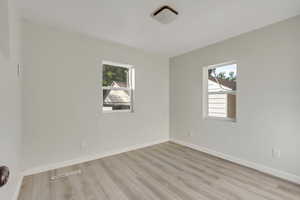 Empty room with plenty of natural light and light hardwood / wood-style floors