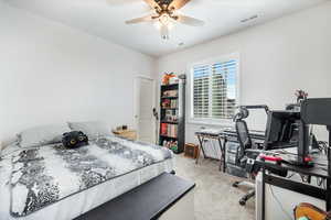 Carpeted bedroom featuring ceiling fan