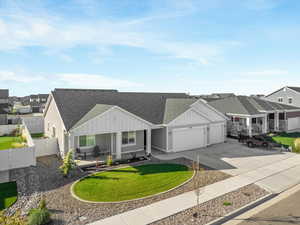 View of front of property featuring a garage and a front lawn