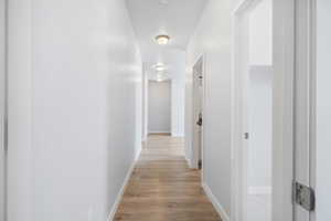 Hallway with light wood-style flooring and baseboards