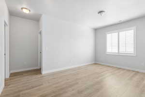 Unfurnished room featuring baseboards, visible vents, and light wood finished floors