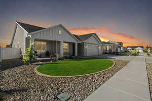 View of front of property featuring a garage and a yard