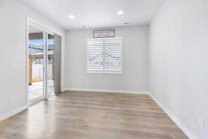 Spare room with light wood-style flooring, visible vents, and a wealth of natural light