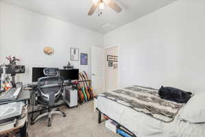 Carpeted bedroom featuring ceiling fan