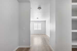 Corridor featuring baseboards and wood finished floors