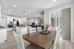 Dining space with sink, ceiling fan, and light hardwood / wood-style flooring