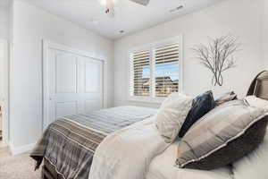 Carpeted bedroom with a closet and ceiling fan