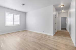 Spare room featuring baseboards and light wood finished floors