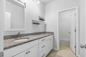 Bathroom featuring toilet, vanity, and tile patterned floors