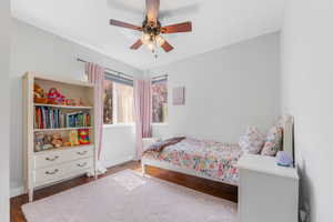 Bedroom featuring dark hardwood / wood-style flooring and ceiling fan