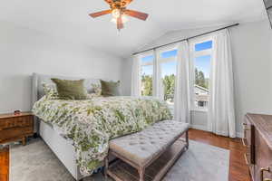 Bedroom with wood-type flooring, ceiling fan, and vaulted ceiling