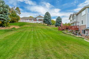 View of back yard featuring a wooden deck. Enjoy water slide in the summer or snow sled in the winter with slope