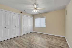 Large size bedroom featuring double closet closets, ceiling fan, and lamiate type flooring