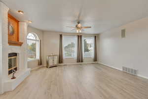 Family room featuring a brick fireplace, ceiling fan, and upgraded LVP flooring