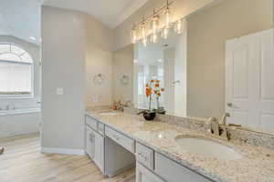 Upgraded masterbathroom featuring LVP flooring, double-sink granite countertop vanity