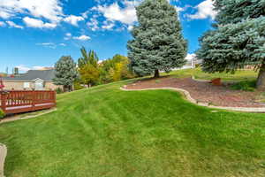 View of back yard featuring a large size wooden deck for gathering ad BBQ