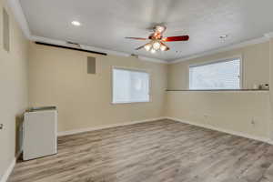 Office or exercise room featuring a wealth of natural light, ceiling fan, and light laminate flooring