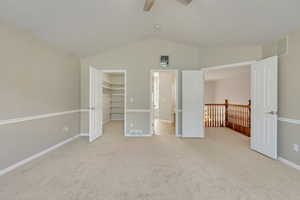 Master Bedroom featuring new carpet, ceiling fan, a spacious closet, vaulted ceiling