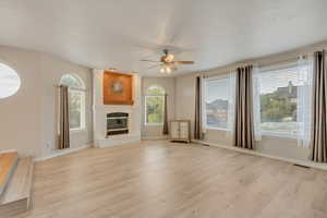 Large family room with ceiling fan, a healthy amount of sunlight, and LVP flooring