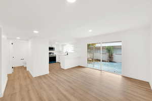 Unfurnished living room featuring light hardwood / wood-style floors and sink