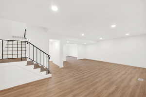 Basement with light hardwood / wood-style flooring