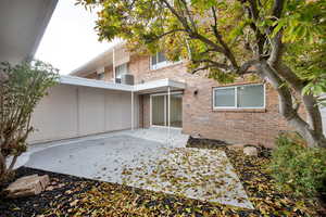 Back of property with cooling unit and a patio