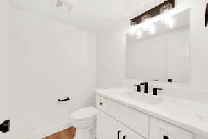 Bathroom featuring hardwood / wood-style flooring, vanity, and toilet