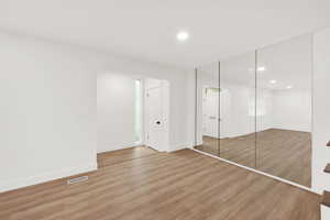 Unfurnished bedroom with light hardwood / wood-style flooring and a closet