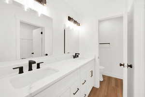 Bathroom with wood-type flooring, toilet, and vanity