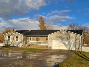 Single story home featuring a garage, a porch, and a front lawn