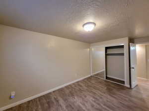 Bedroom featuring a closet, a textured ceiling, and hardwood / wood-style flooring