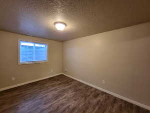 Bedroom with dark wood-type flooring and a textured ceiling