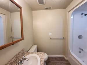 Bathroom with hardwood / wood-style floors, a textured ceiling, and toilet