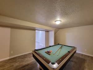 Playroom featuring dark hardwood / wood-style flooring, a textured ceiling, and billiards table