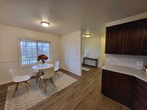 Dining space featuring hardwood / wood-style floors and a textured ceiling