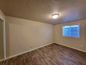 Bedroom with dark wood-type flooring and a textured ceiling