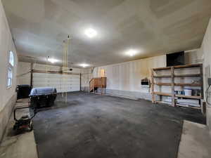 Huge garage featuring a garage door opener, heater and storage shelves.