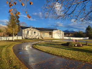 View of front of property with a mountain view, a garage, and a front lawn