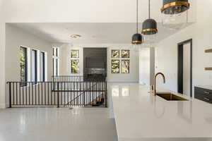 Kitchen with a wealth of natural light, sink, and hanging light fixtures