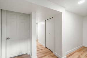 Hallway in basement leading to bedrooms, bathroom, laundry room and storage.