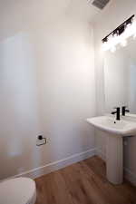 Bathroom featuring hardwood / wood-style floors, toilet, and lofted ceiling