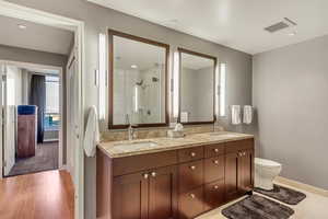 Bathroom featuring toilet, an enclosed shower, vanity, and hardwood / wood-style floors