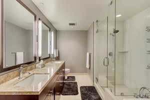 Bathroom featuring vanity, tile patterned flooring, toilet, and an enclosed shower