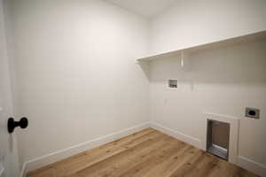 Laundry area featuring hookup for a washing machine, electric dryer hookup, and hardwood / wood-style floors