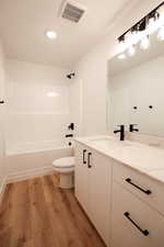 Full bathroom with hardwood / wood-style flooring, vanity, toilet, and shower / bathing tub combination