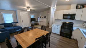 Dining area with lofted ceiling, a healthy amount of sunlight, ceiling fan, and dark hardwood / wood-style floors