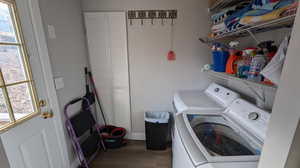 Washroom featuring hardwood / wood-style flooring, washer and dryer, and a healthy amount of sunlight