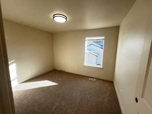 Empty room featuring dark carpet