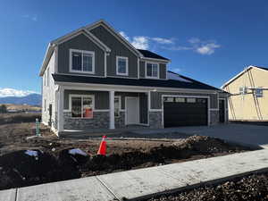 View of front of house featuring a garage, a mountain view, and a porch