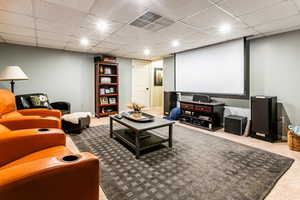 Cinema room with a drop ceiling and carpet